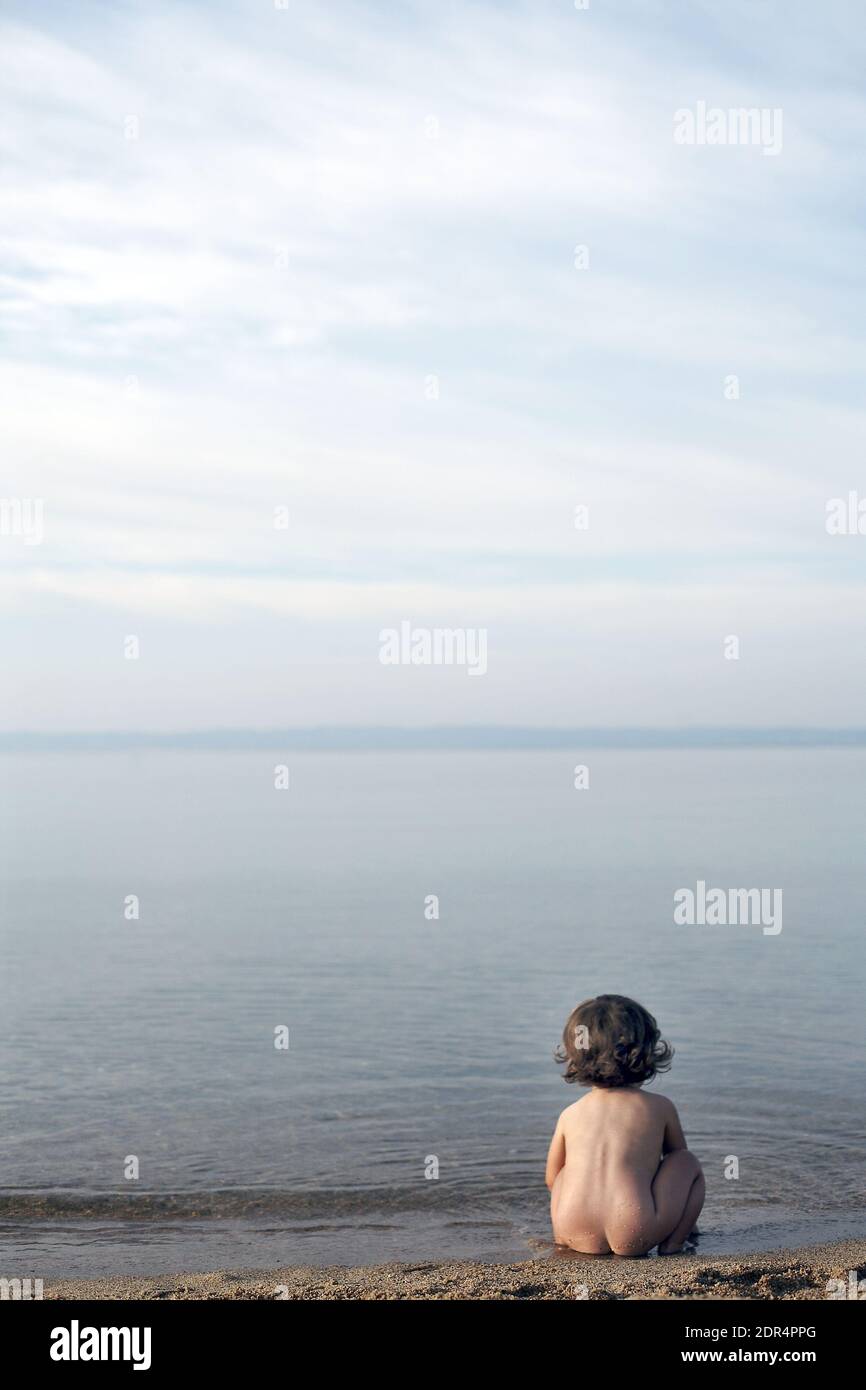 Lonely girl sitting on the beach Stock Photo