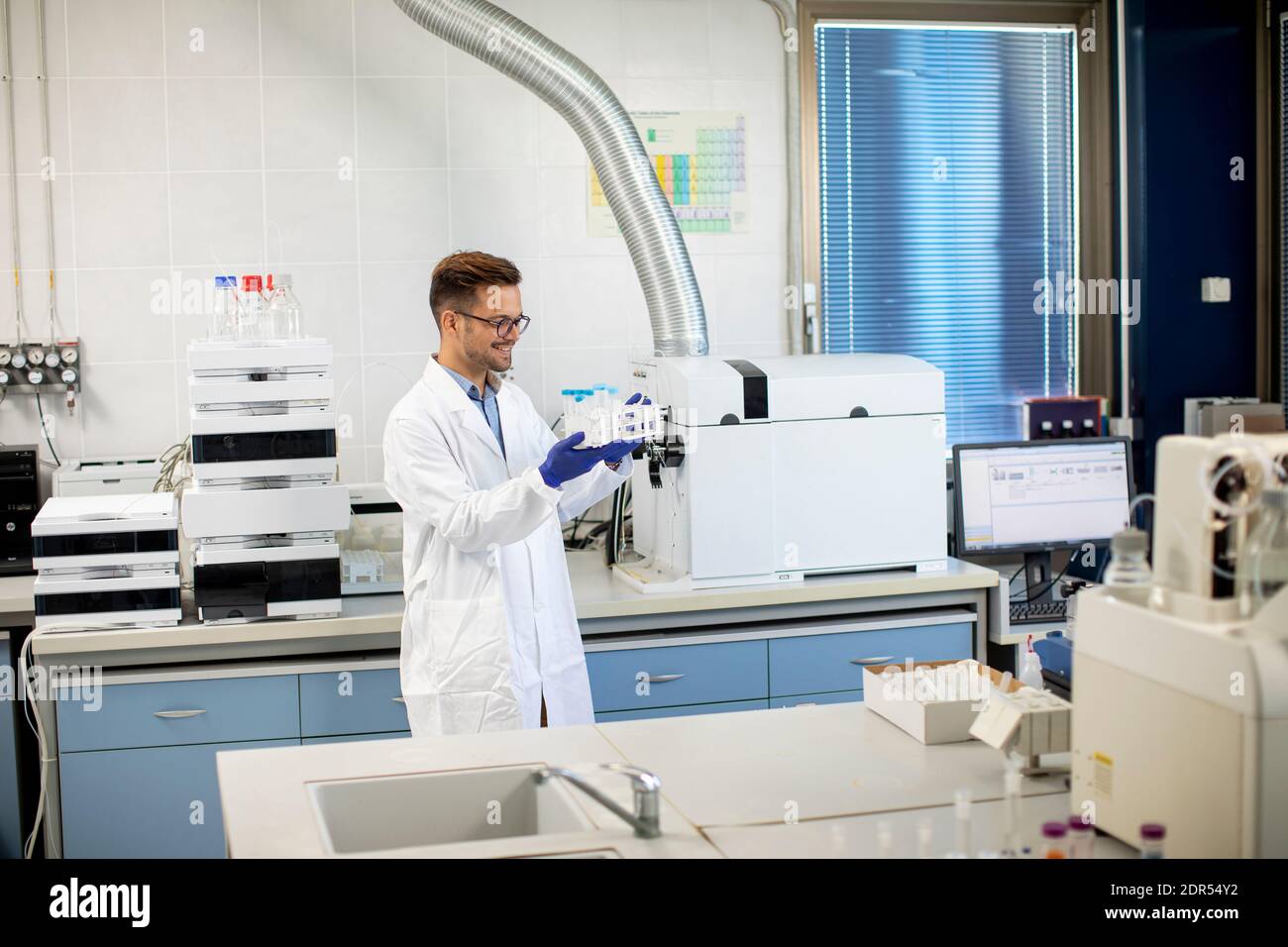 Handsome young researcher workin with chemical samples in laboratory