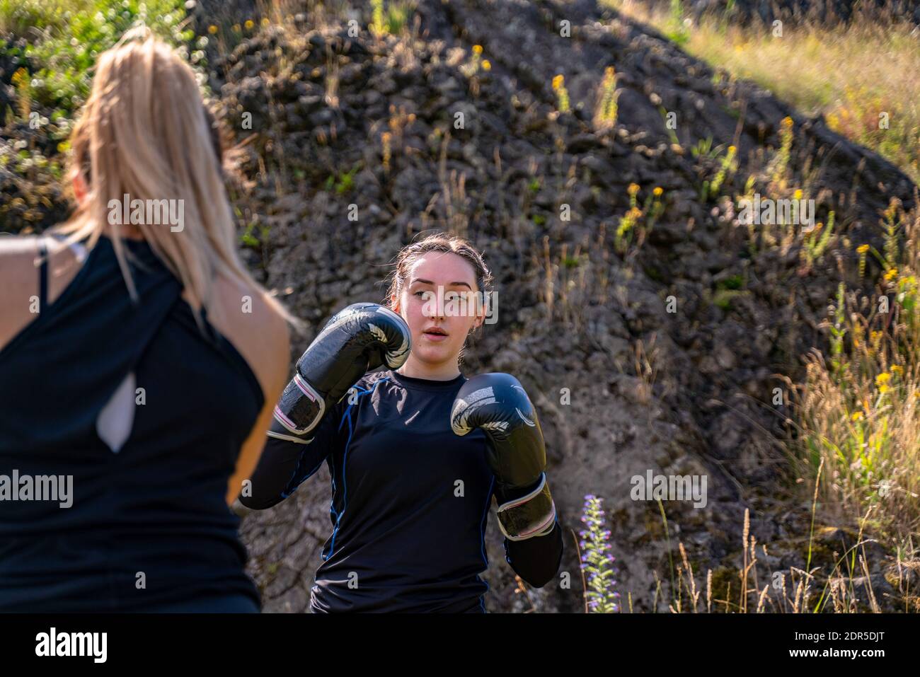 People training during a boxing class outdoor, using boxing mitts with a partner Stock Photo