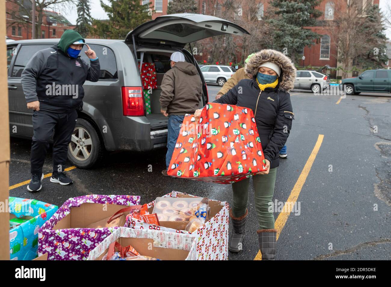Detroit, Michigan, USA. 19th Dec, 2020. At St. Hedwig Catholic Church, the Michigan Muslim Community Council, in partnership with St. Hedwig's, delivered food boxes and Christmas packages to families in need. Volunteers placed boxes in cars as they drove through the church parking lot. The food boxes came from the U.S. Department of Agriculture. Credit: Jim West/Alamy Live News Stock Photo