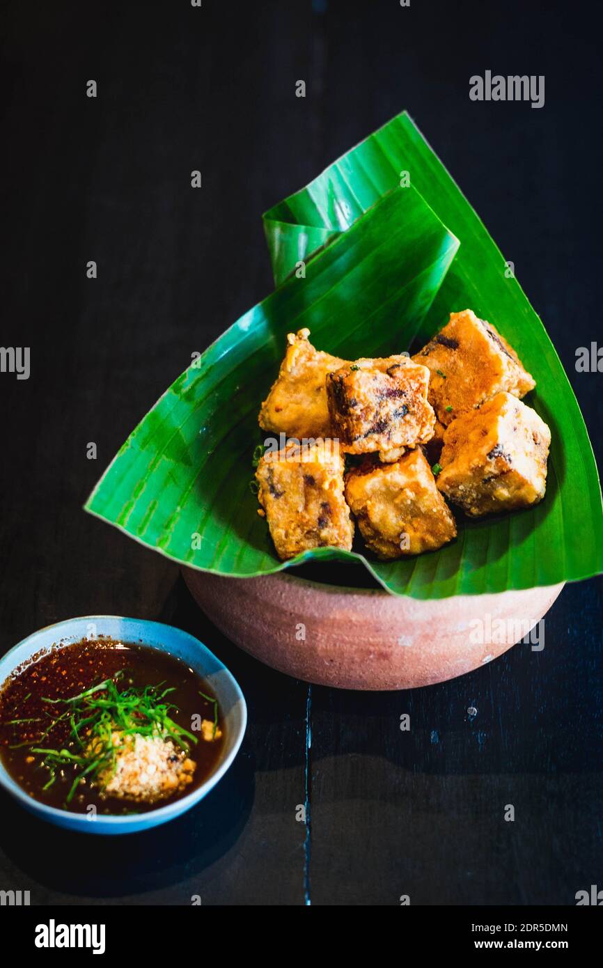 an appetizer of deep fried tofu cubes served in banana leaf with a