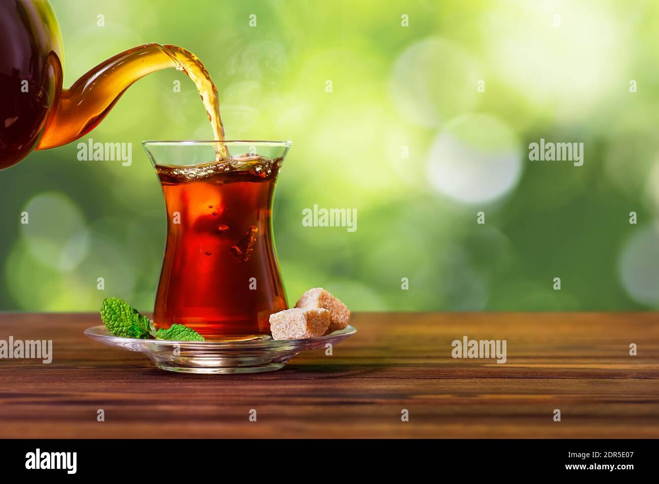 tea pouring from teapot into glass Stock Photo