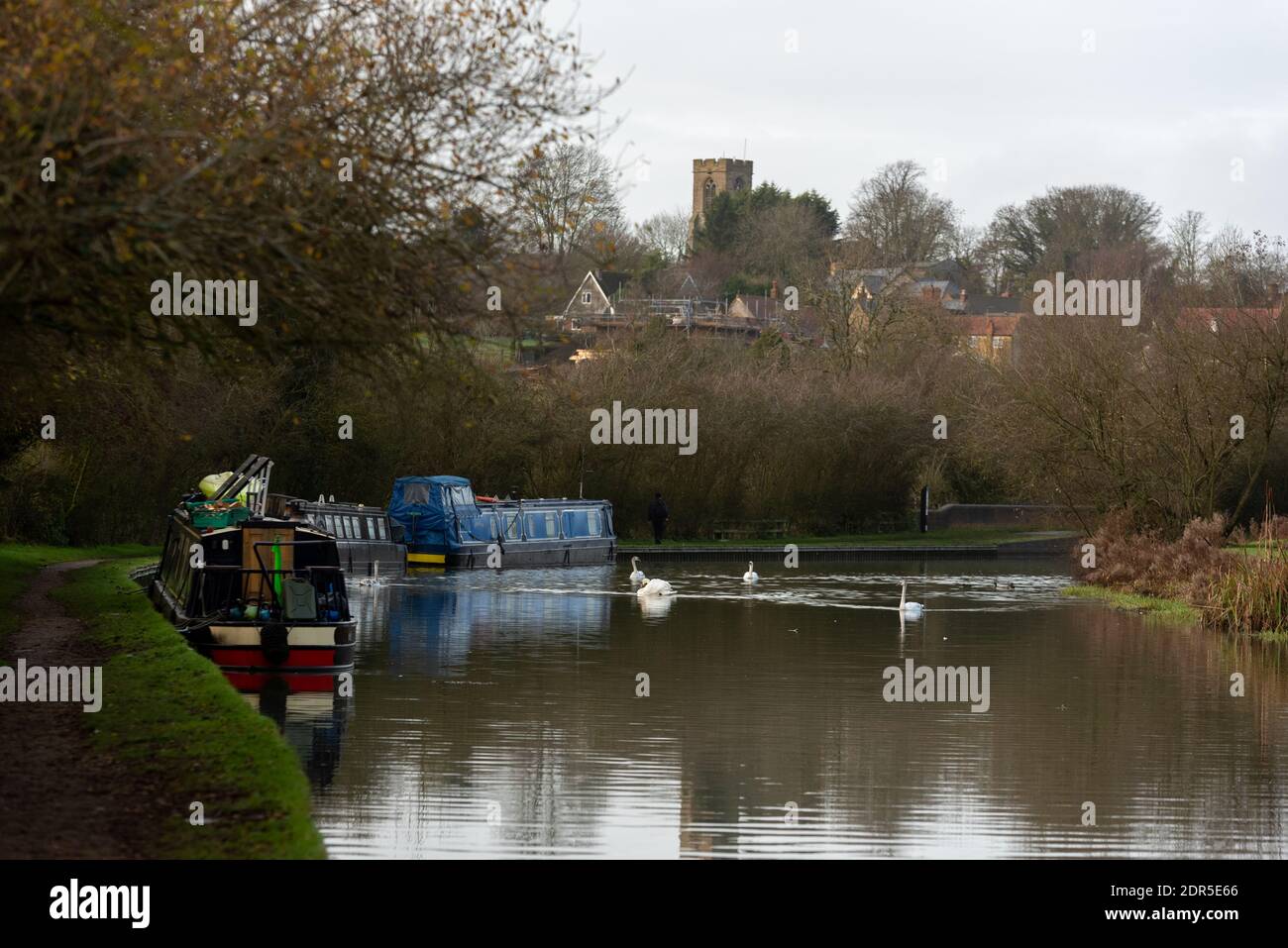 canal stbuenes northampton scene with canal boats moored round bend with church in background Stock Photo