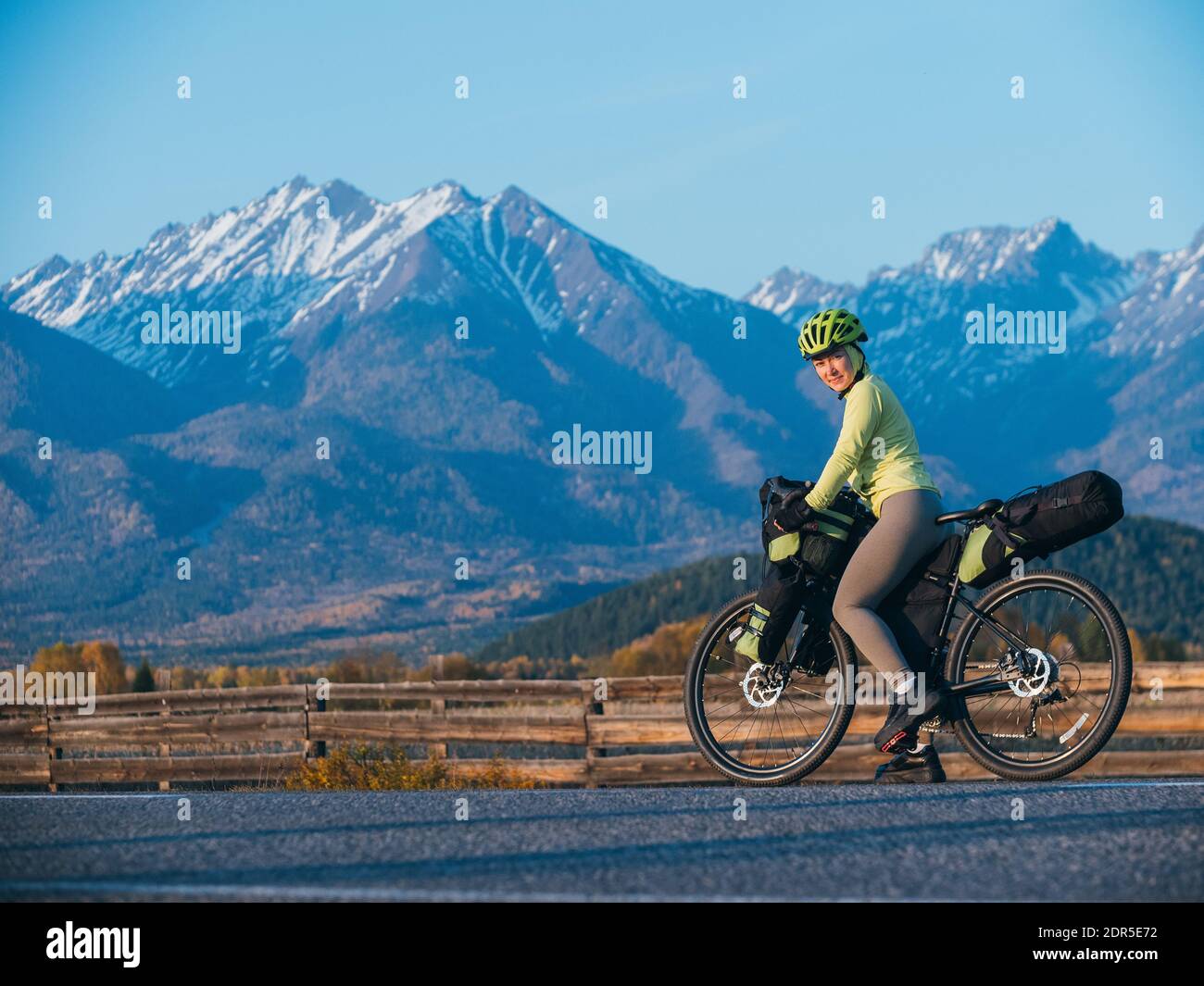 The woman travel on mixed terrain cycle touring with bikepacking. The traveler journey with bicycle bags. Sport tourism bikepacking. Stock Photo