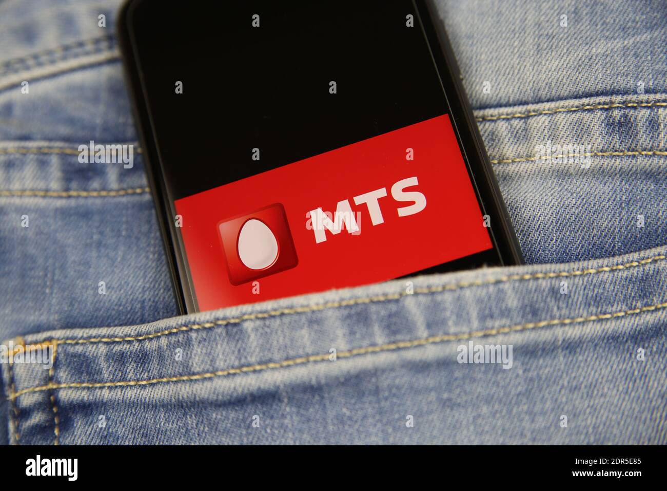 Viersen, Germany - May 9. 2020: Close up of smartphone screen in blue jeans pocket with logo lettering of russian mobile phone provider MTS Telesystem Stock Photo