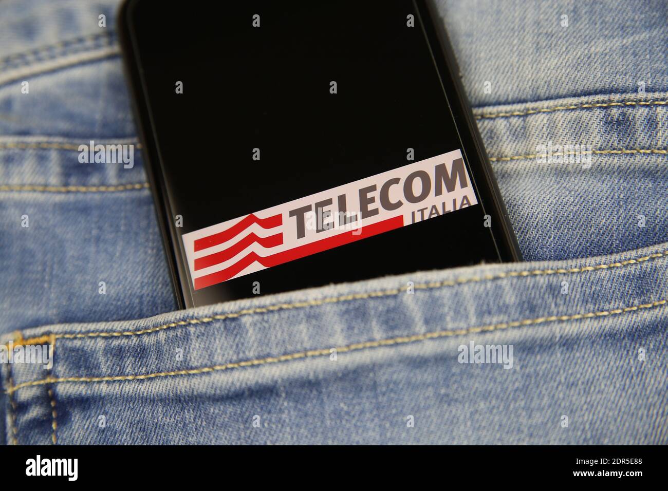Viersen, Germany - May 9. 2020: Close up of smartphone screen in blue jeans pocket with logo lettering of italian mobile phone provider Telecom Italia Stock Photo