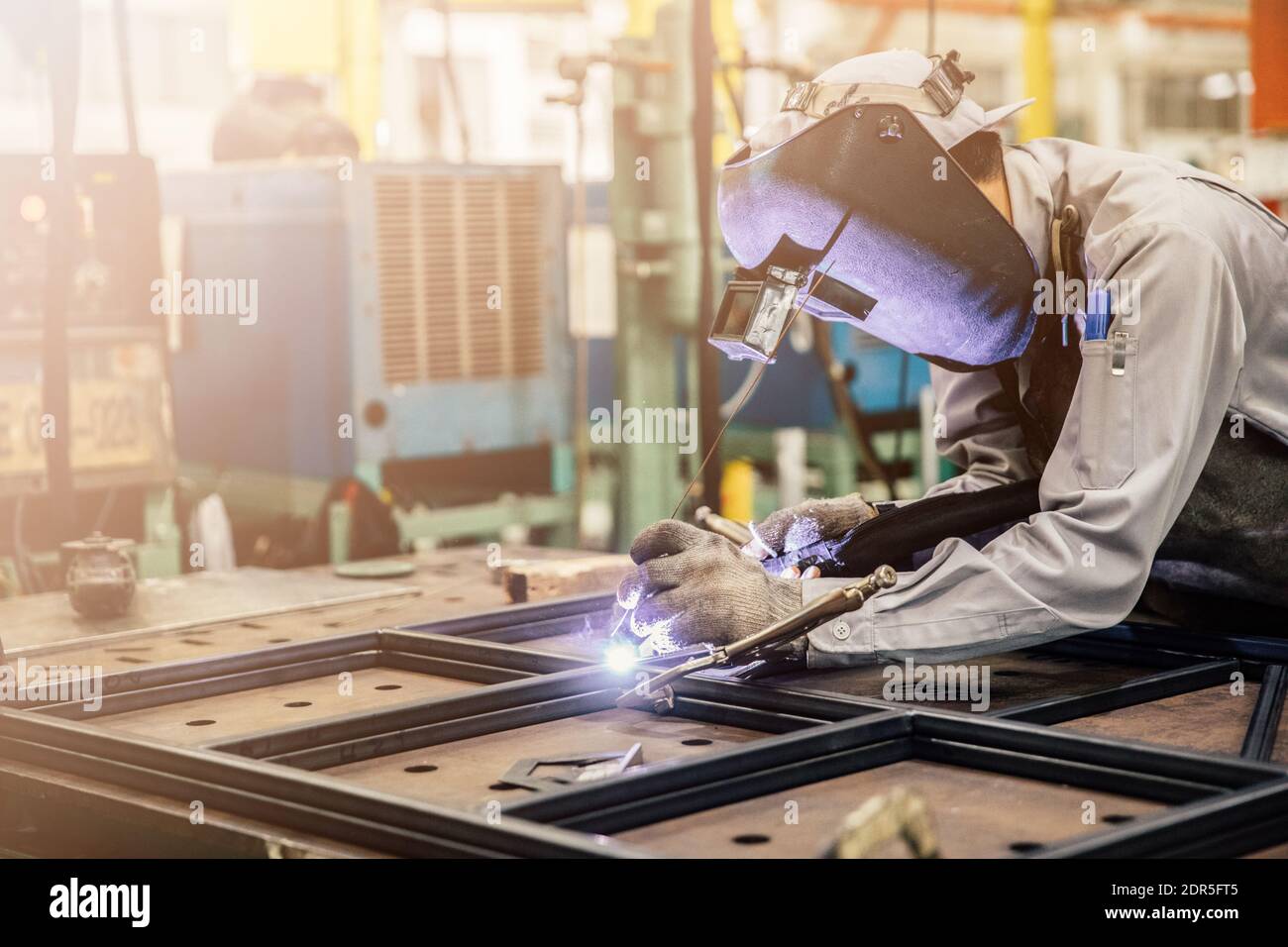 Industrial worker in manufacturing plant grinding to finish a Metal pipe,Industrial Worker at