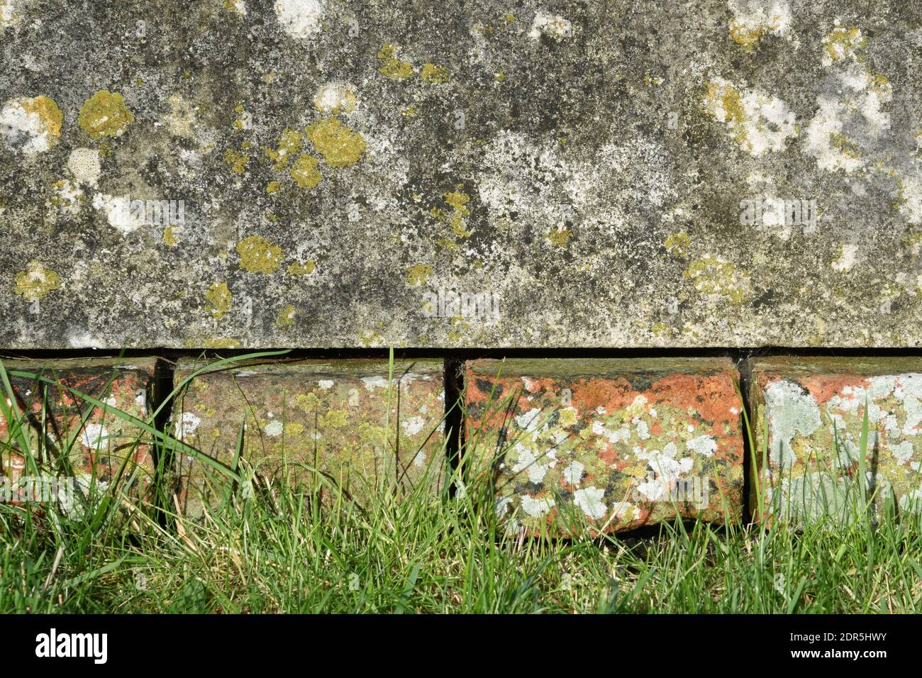 Old bricks, stone, and grass background. Stock Photo