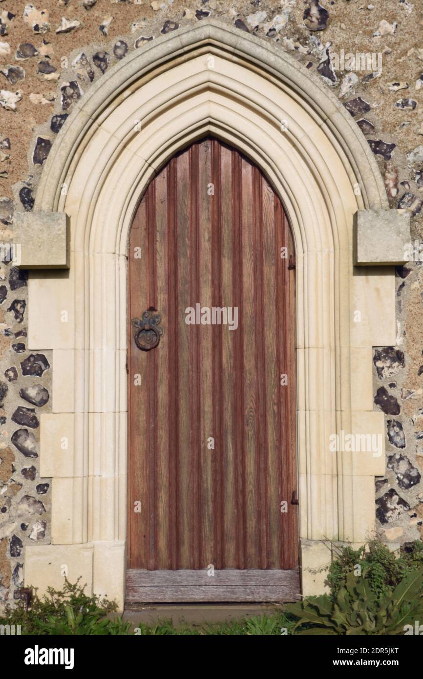 Vintage arched wooden door set in a stone church wall architecture, St ...