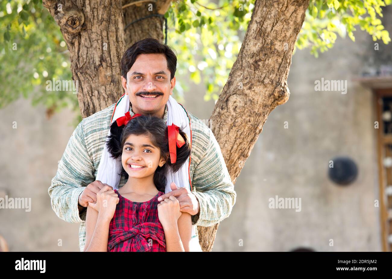 Rural Indian father with daughter looking at camera Stock Photo