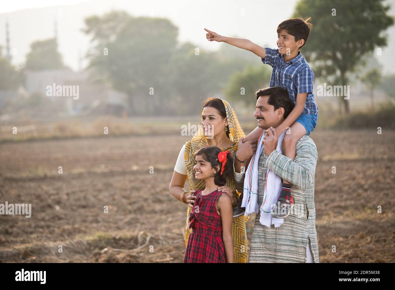 Happy rural Indian family on agricultural field Stock Photo