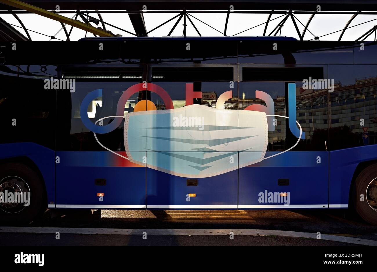 Coronavirus, Covid 19 mask advertising sign warning on the side of a bus. Public transportation. Rome, Italy, Europe, EU Stock Photo