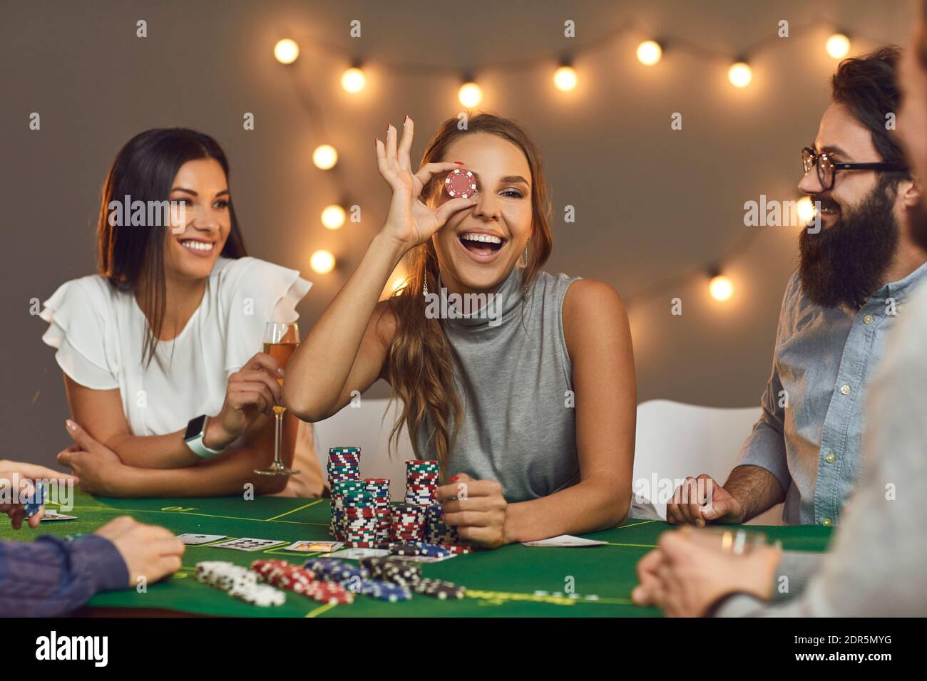 Group of smiling friends playing board games with chips at home Stock Photo