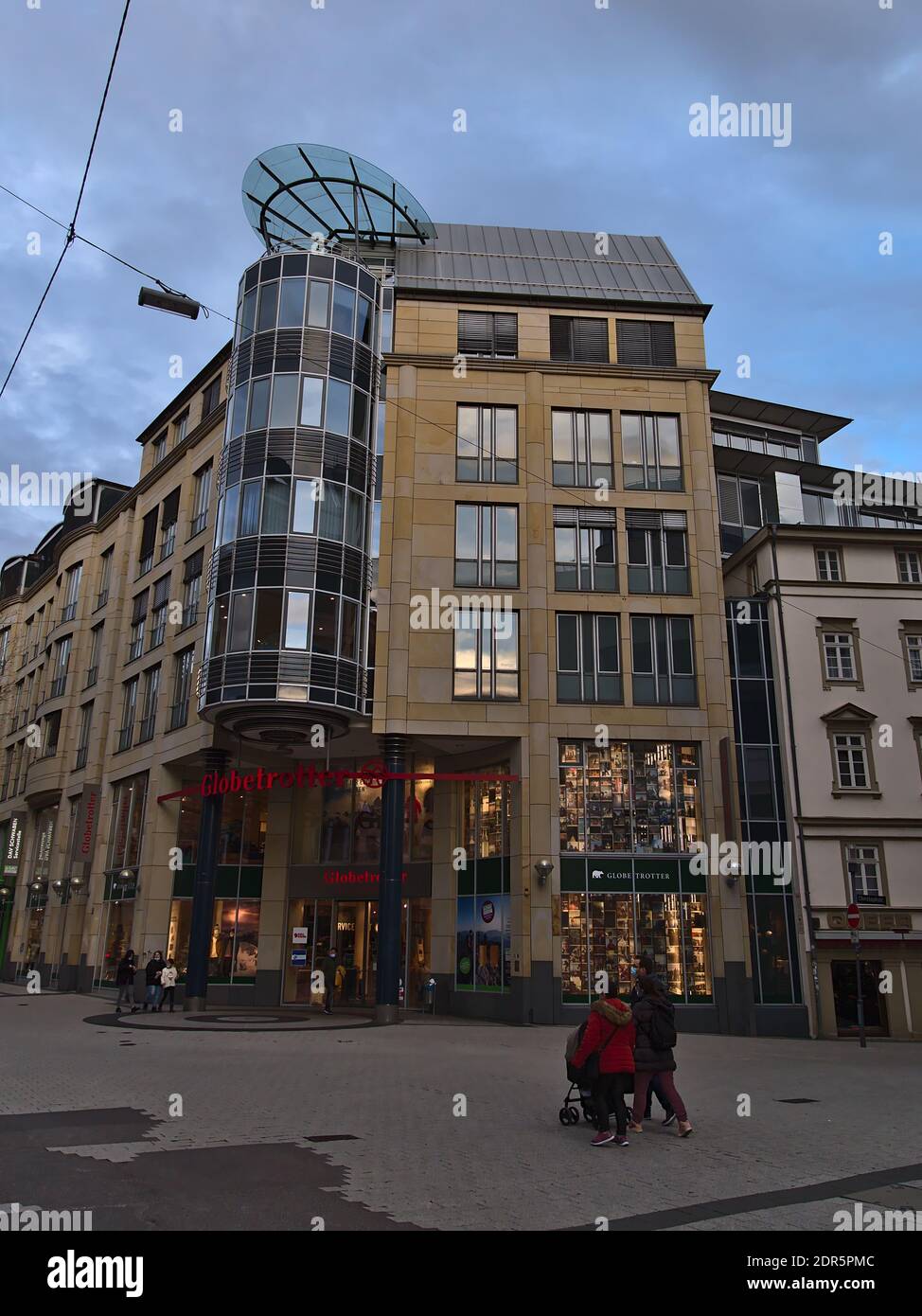 Front view of closed branch of Globetrotter, a German retailer for outdoor products, in shopping street Tübinger Straße with people wearing face masks. Stock Photo