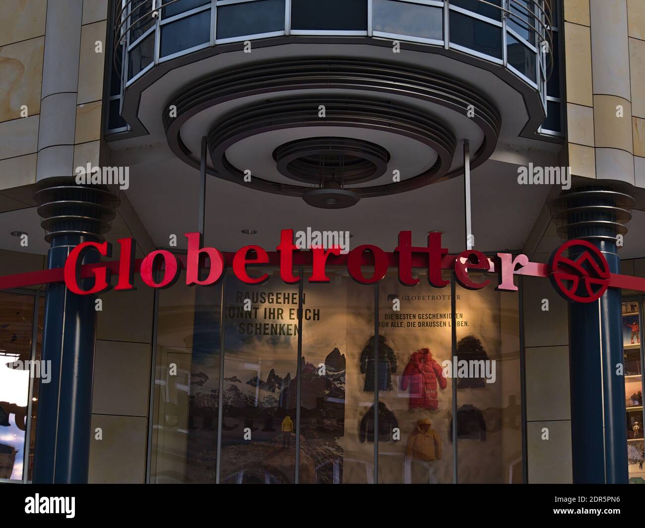 Red colored logo of German outdoor supply chain Globetrotter above shop entrance of the company's branch in shopping street Tübinger Straße. Stock Photo