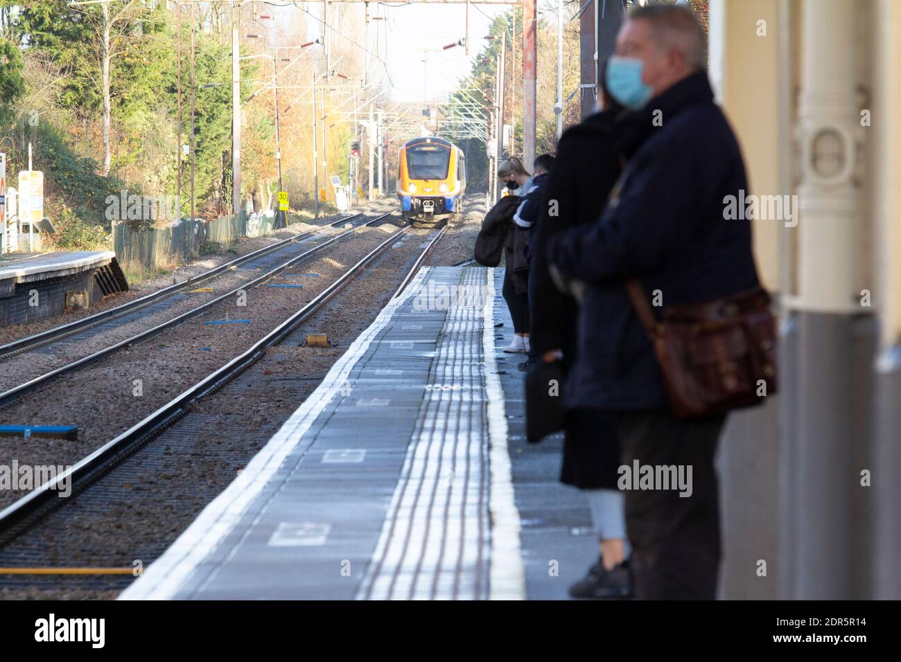 Passengers wait for train wearing masks during Covid pandemic on London