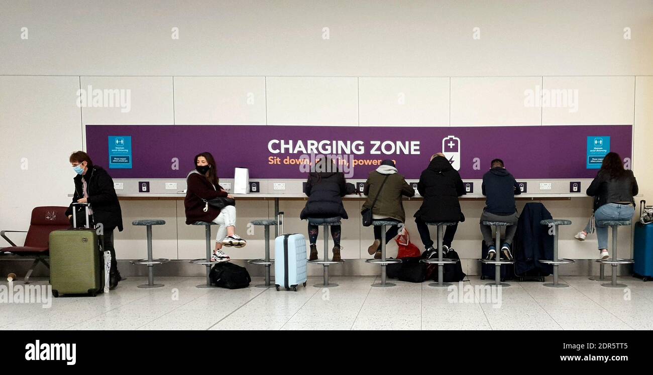 Passengers use a charging zone as they wait to check-in for flights at Gatwick Airport in West Sussex, amid concerns that borders will close and with the public being urged to adhere to Government guidance after Prime Minister Boris Johnson announced on Saturday that from Sunday areas in the South East currently in Tier 3 will be moved into a new Tier 4 for two weeks Ð effectively returning to the lockdown rules of November, after scientists warned of the rapid spread of the new variant coronavirus. Stock Photo