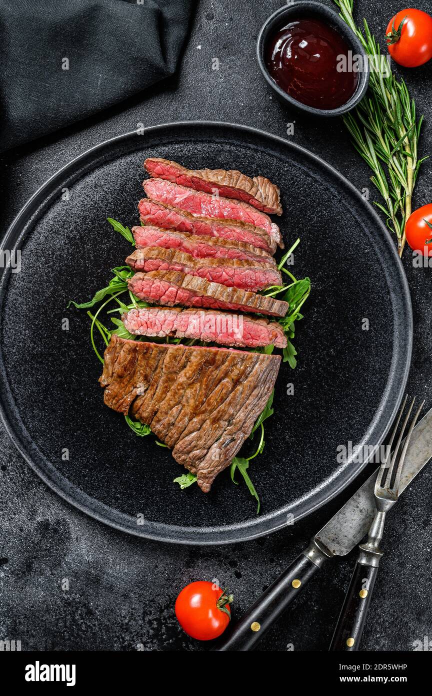 Grilled and cut Flat Iron steak. Marble beef meat. Black background
