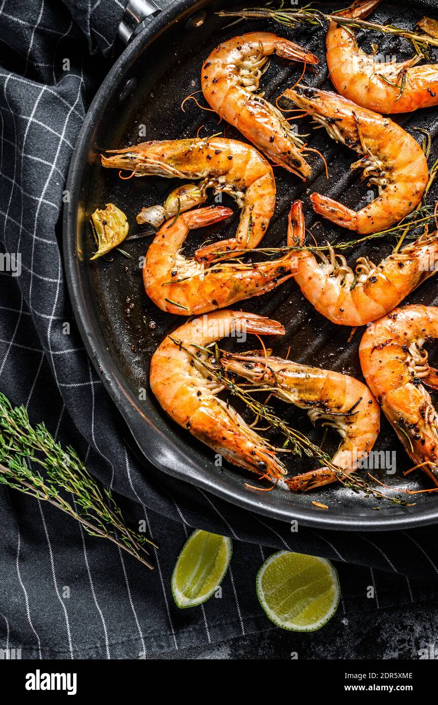 Grilled giant langoustine shrimps, prawns in a frying pan. Black