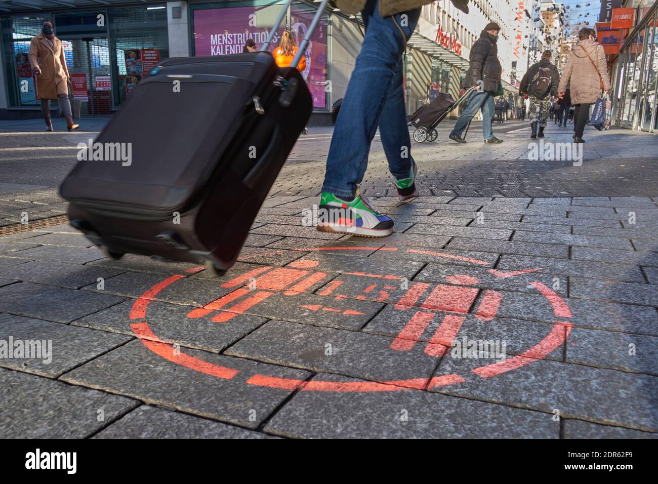 Notice on the floor reminding of the distance rules in the pedestrian zone in Cologne Stock Photo