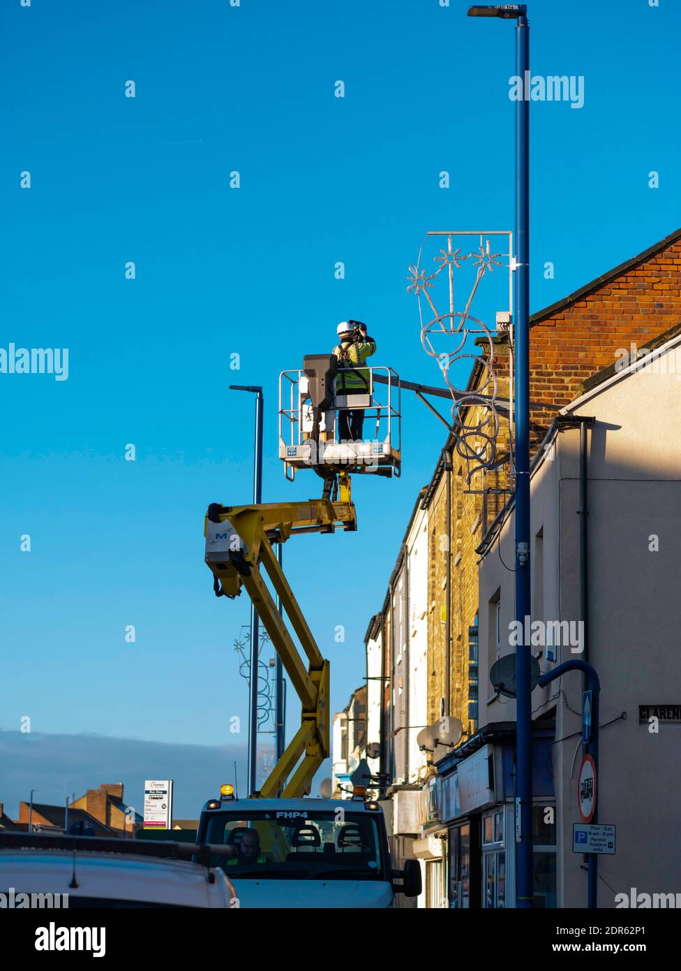 Man on an Hydraulic Hoist carrying out a repair to a CCTV camera Stock