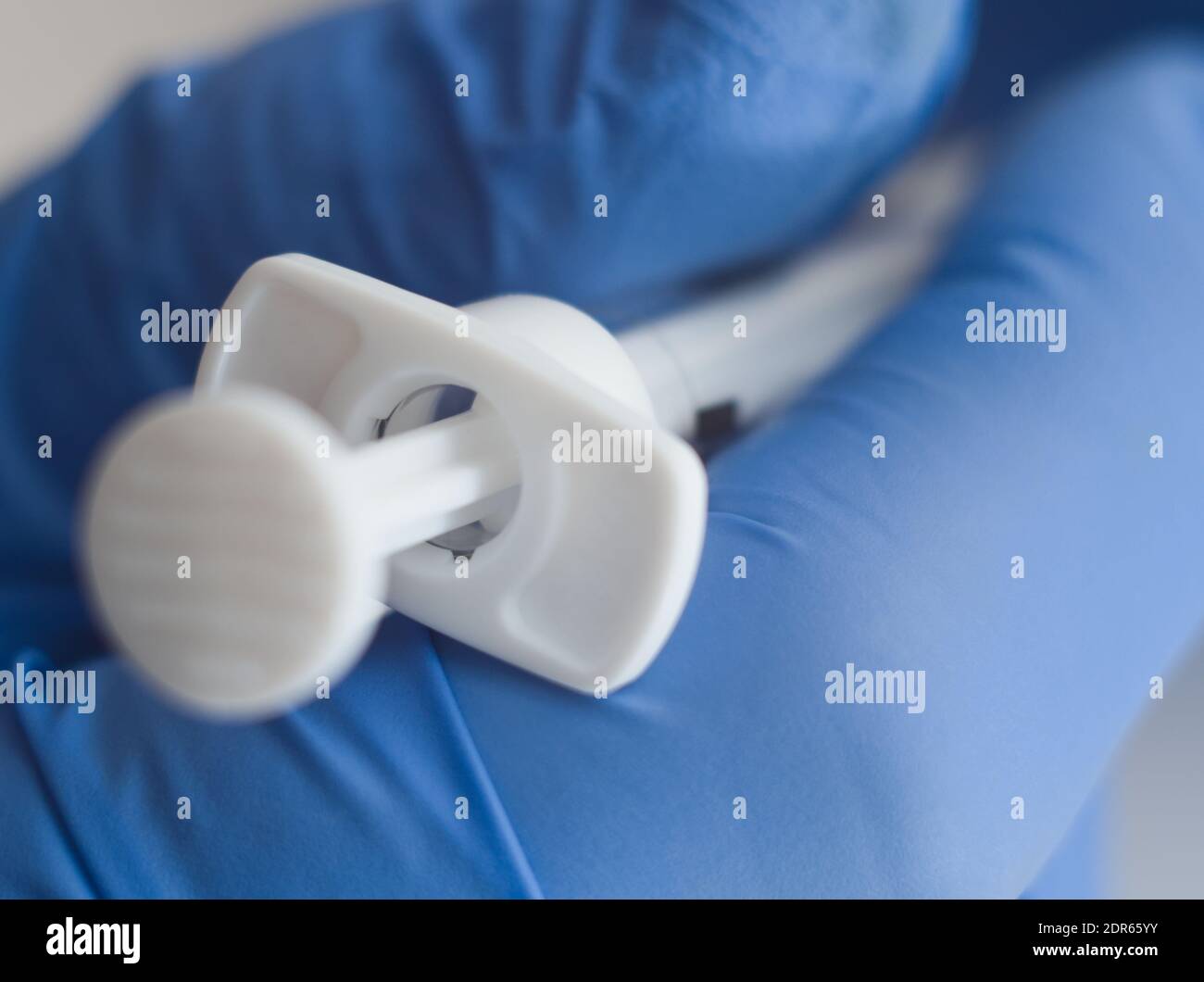Hand in Blue Rubber Gloves Holding Medical Syringe Macro Closeup on White Background Stock Photo