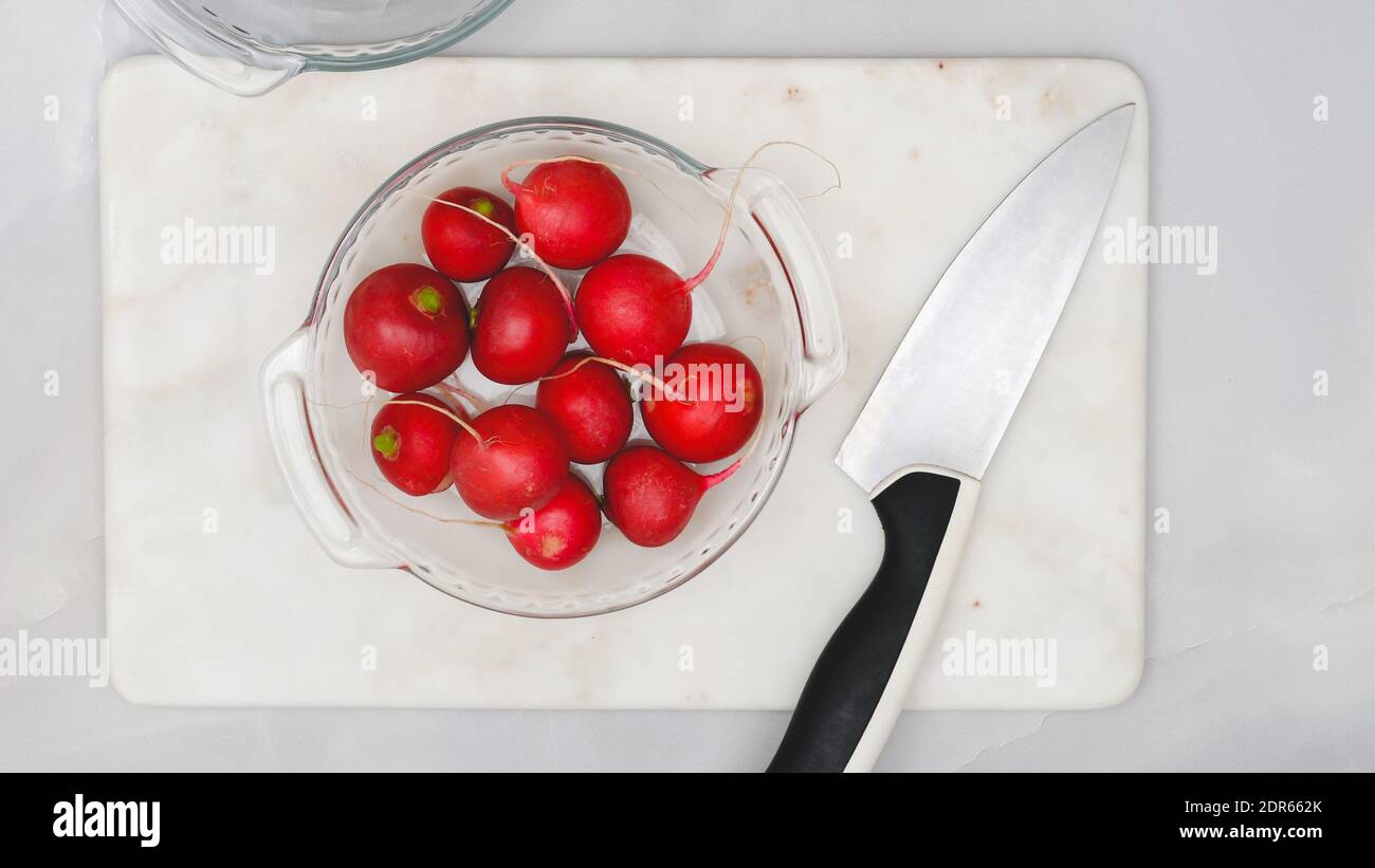 Fresh organic radish closeup on a plate on marble background , flat lay Stock Photo