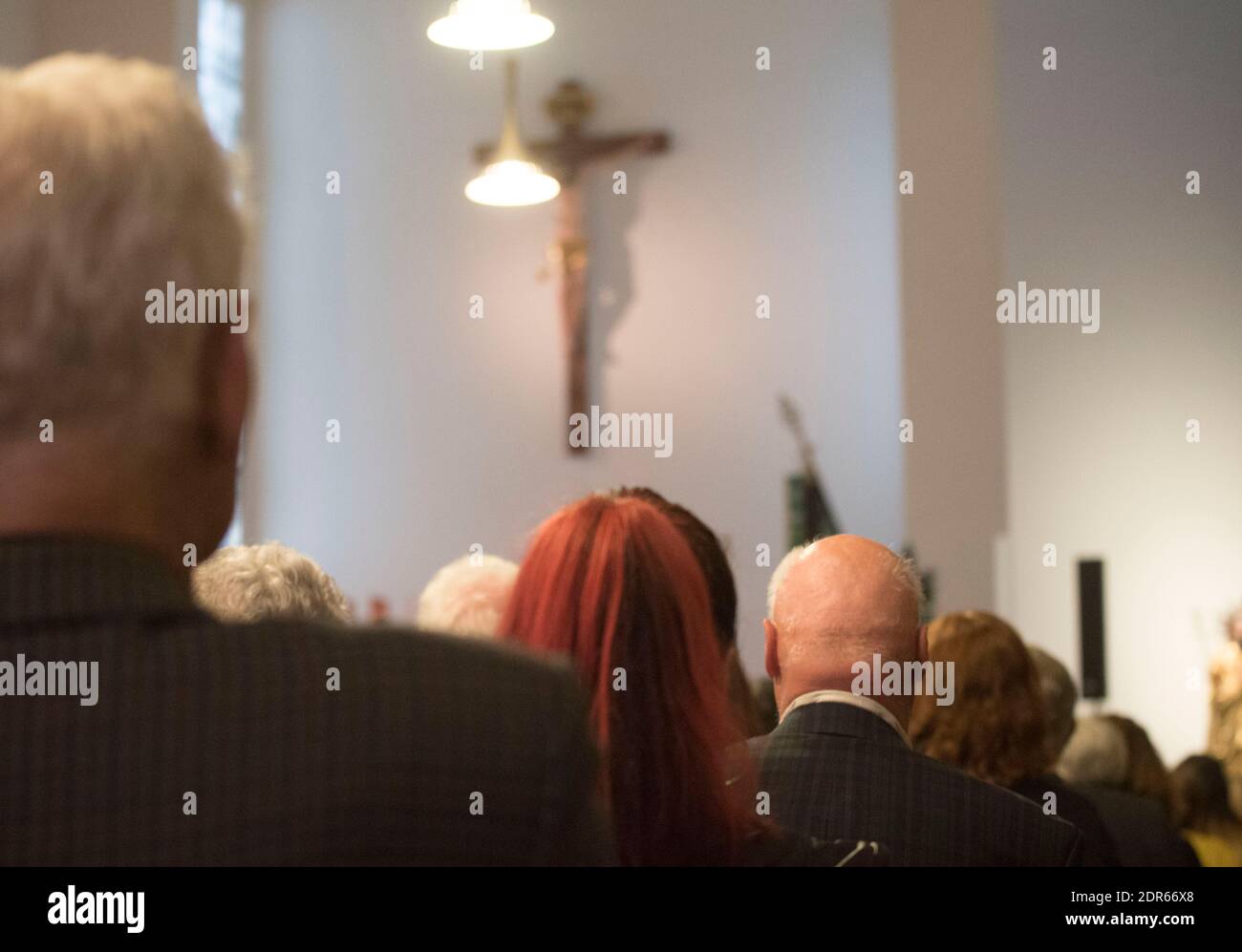 people mourning after someone died in a church at a funeral service Stock Photo