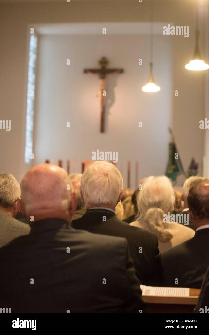 people mourning after someone died in a church at a funeral service Stock Photo