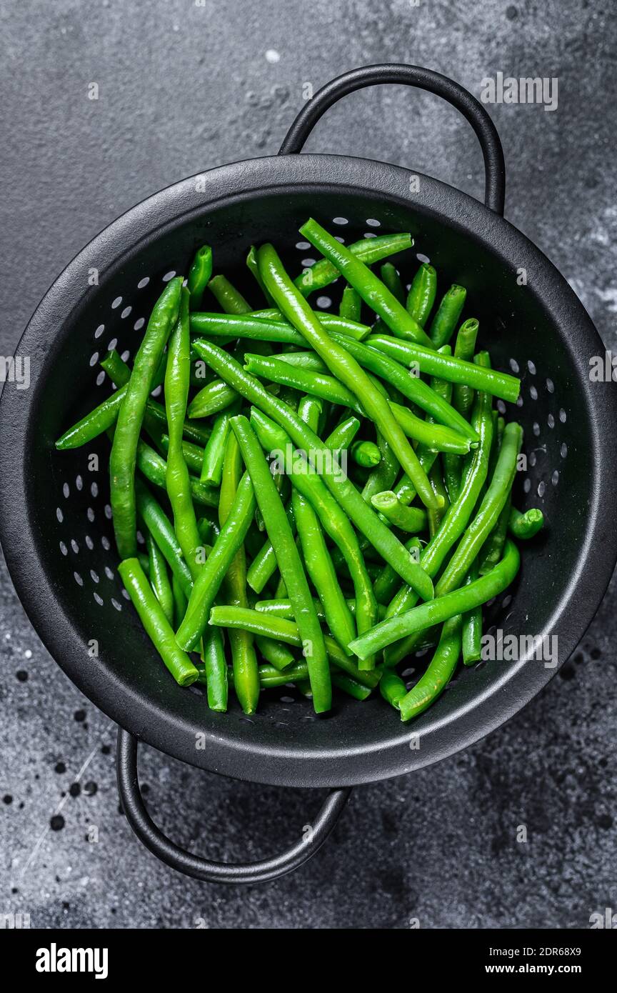 Raw green beans in a colander. Black background. top view Stock Photo ...