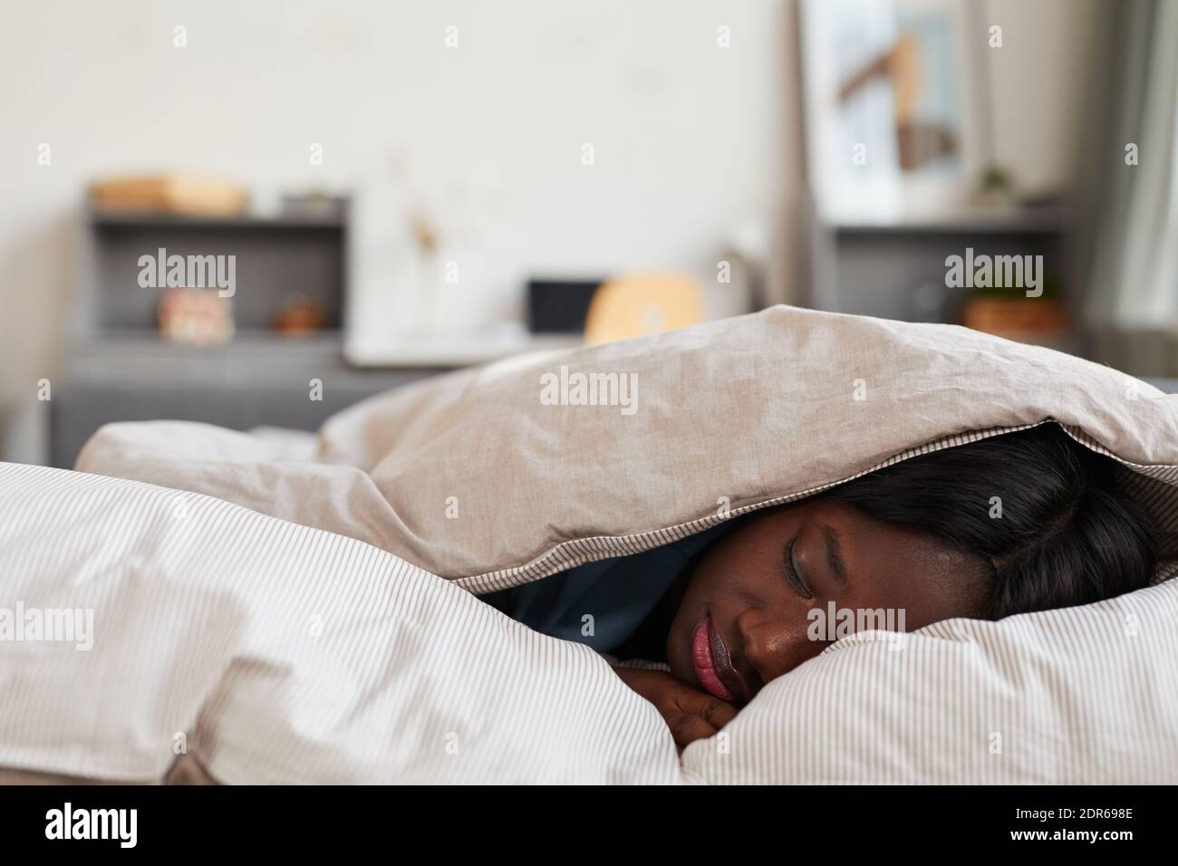 Young woman sleeping under blanket hi res stock photography and images Alamy