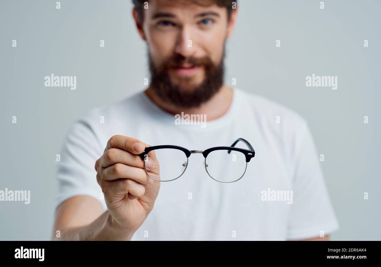 a man with glasses in his hand vision problems eye pain myopia