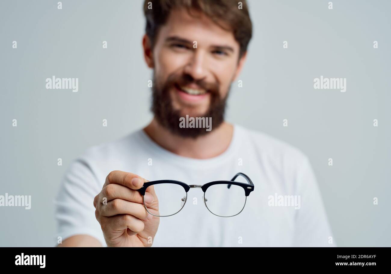 a man with glasses in his hand vision problems eye pain myopia