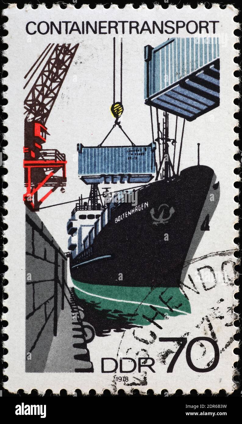 Loading containers on a cargo in old postage stamp Stock Photo