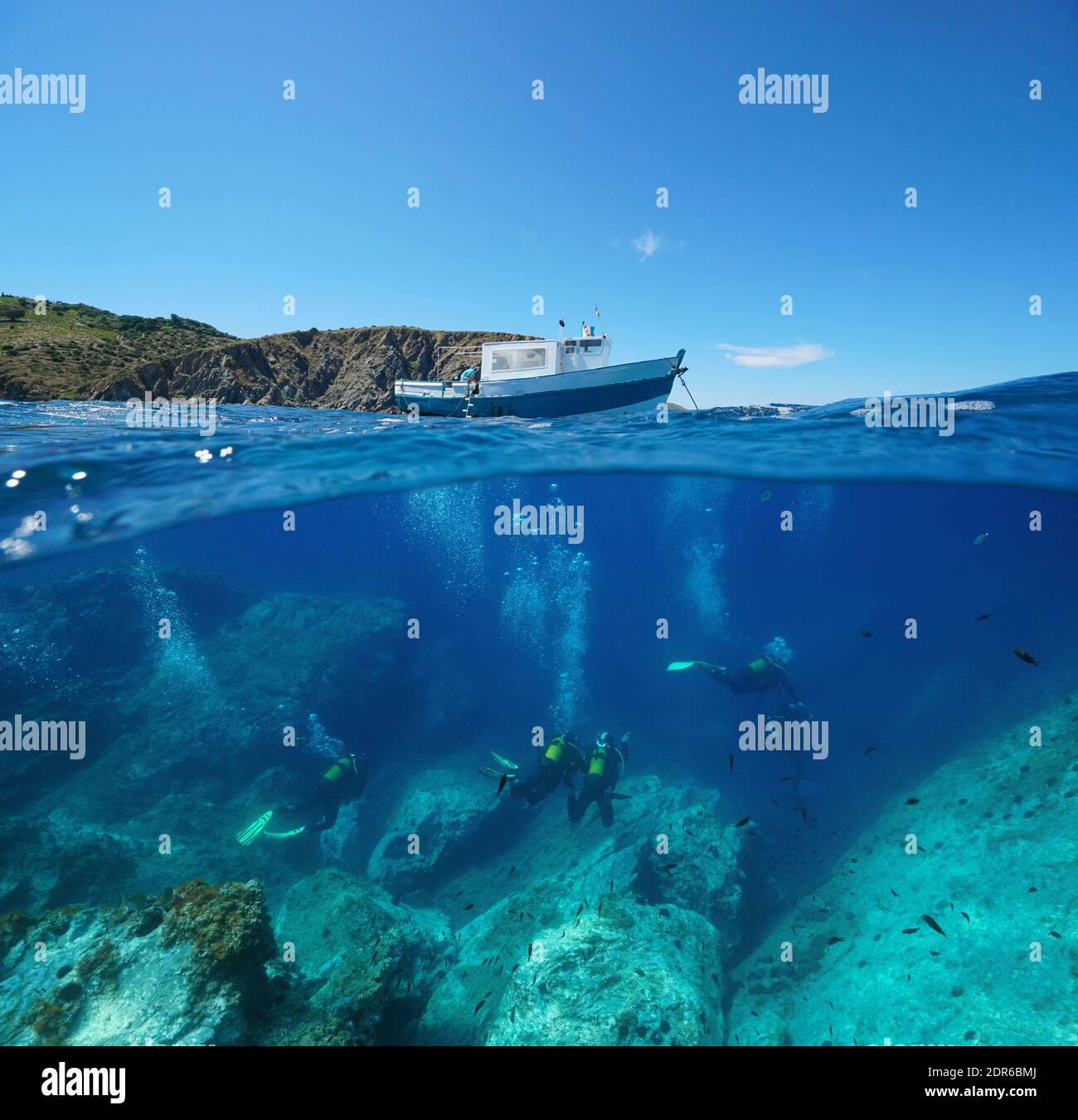 Scuba diving, a boat on the surface and scuba divers underwater, Mediterranean sea, split view over and under water, Marine reserve of Cerbere Banyuls Stock Photo