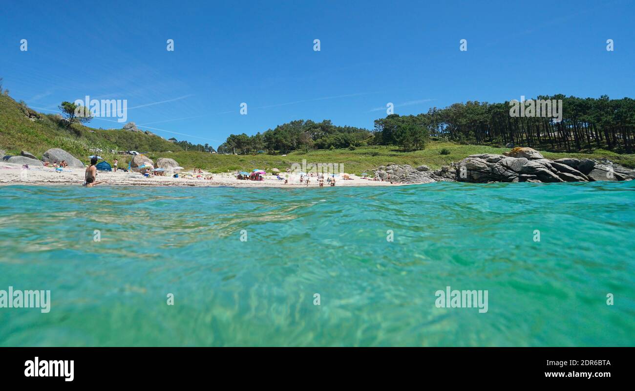 Spain Galicia coastline, beach with tourists in summer vacations seen from water surface, Atlantic ocean, Bueu, Pontevedra province Stock Photo