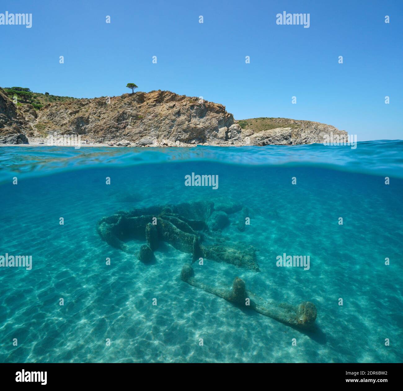 France Occitanie, rocky coast and the remains of a wrecked ship underwater, split view over and under water surface, Mediterranean sea Stock Photo