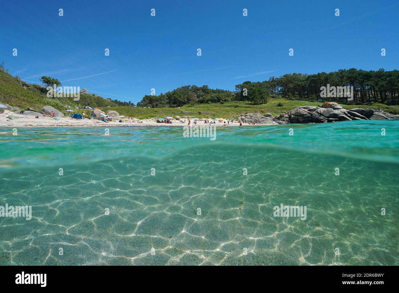 Spain Galicia coastline, beach in summer vacations and sand underwater, split view over and under water surface, Atlantic ocean, Bueu, Pontevedra Stock Photo