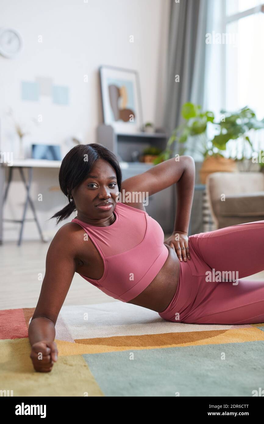 Portrait of smiling African-American woman wearing pink sportswear during workout at home Stock Photo