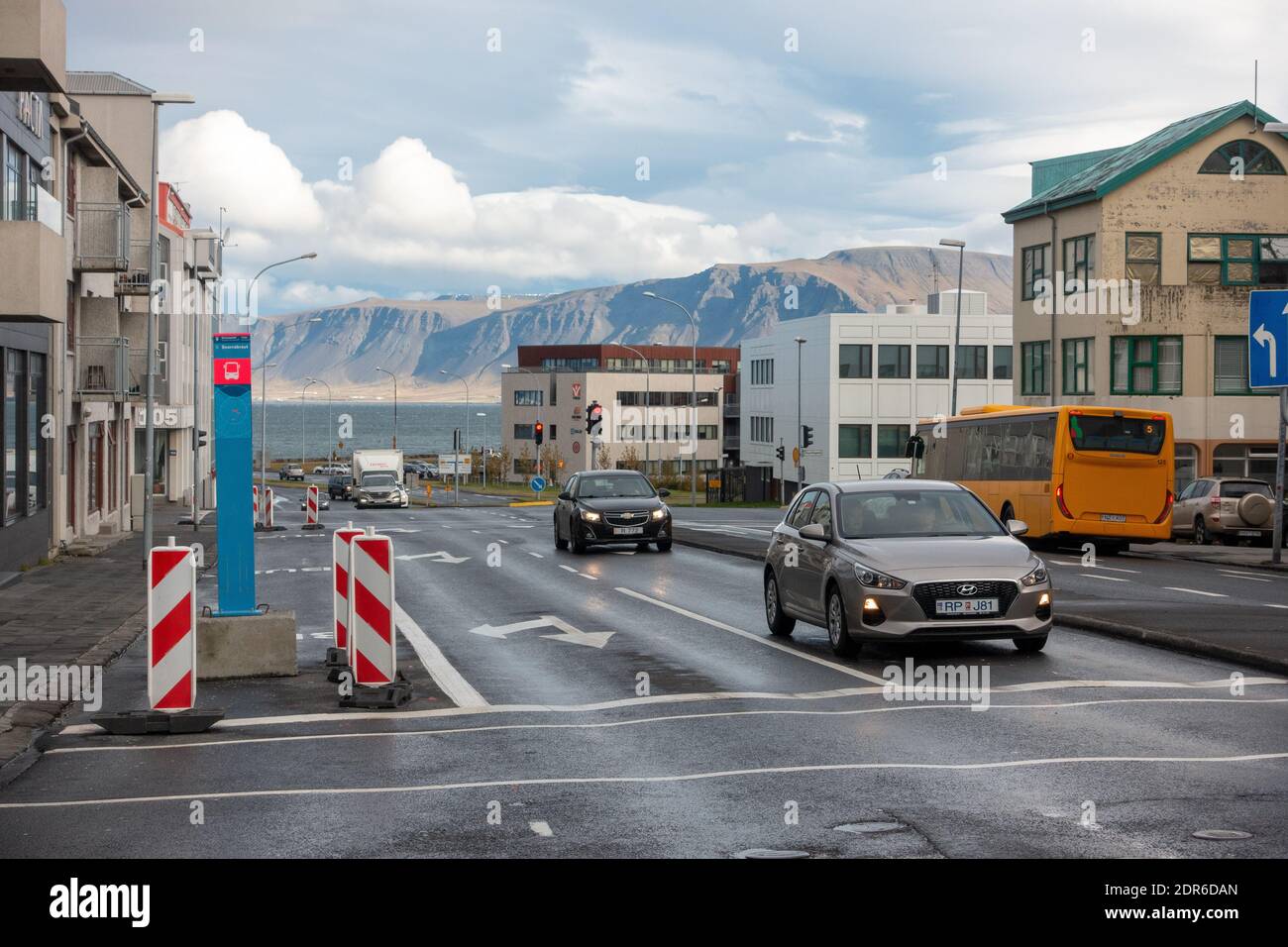 Snorrabraut  Street In Reykjavík With Videy Island In The Background Public Bus And Private Cars, The Ocean In Kollafjordur Bay Stock Photo