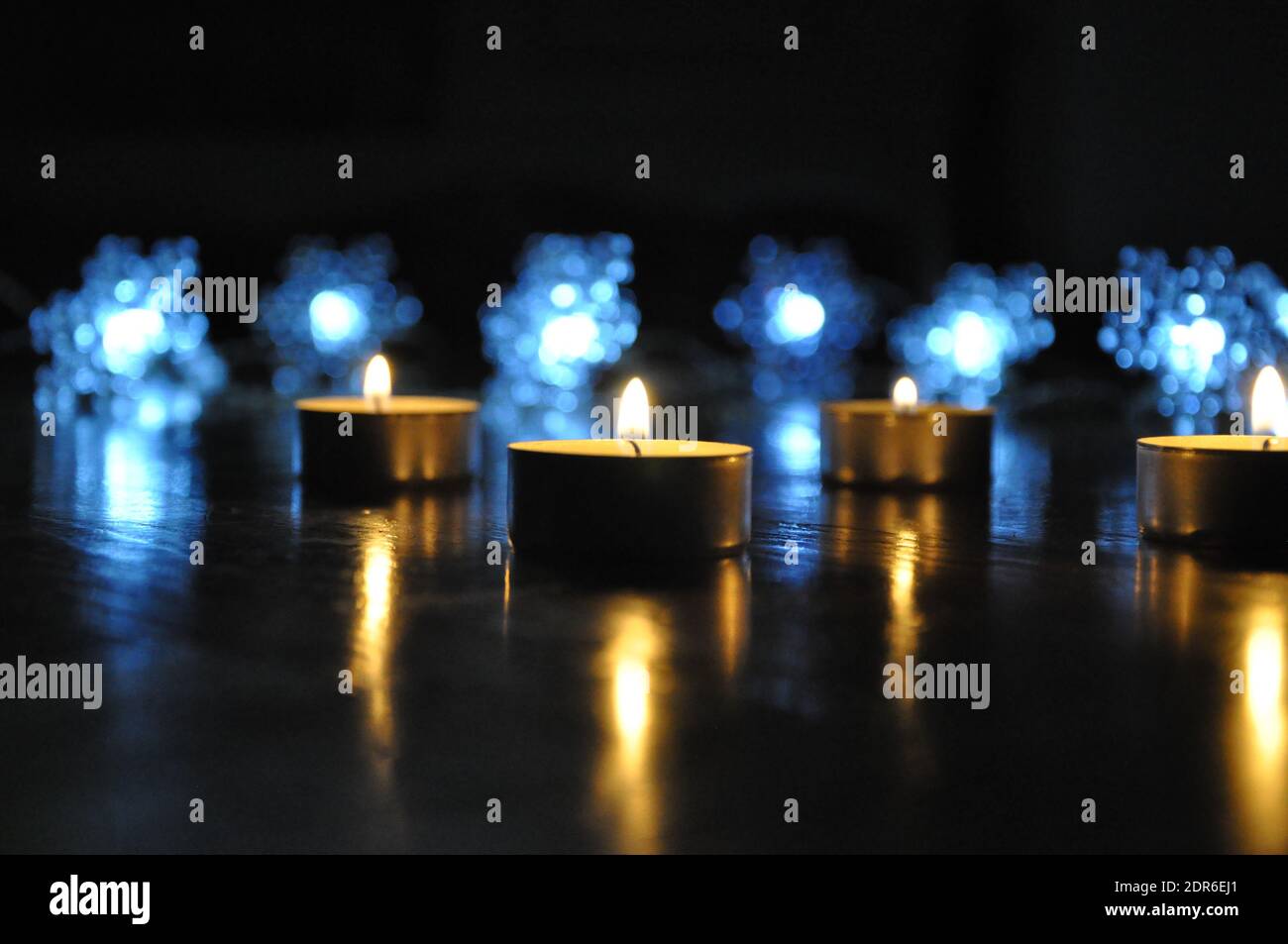 Christmas candles burning at night.  Golden light of candle flame. Decoration, black.Abstract candles background. Stock Photo