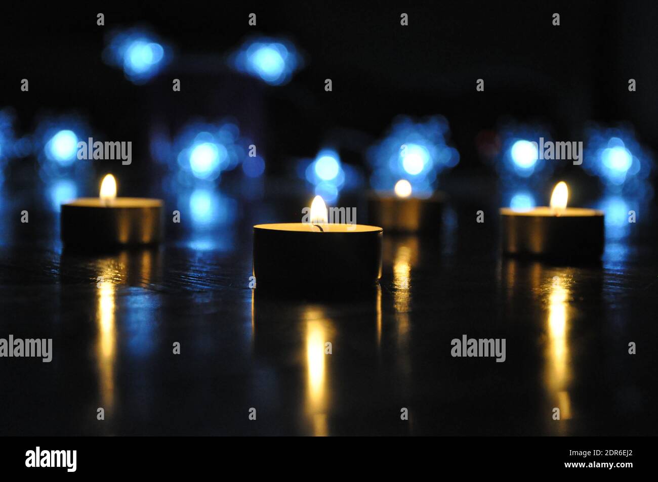 Christmas candles burning at night.  Golden light of candle flame. Decoration, black.Abstract candles background. Stock Photo