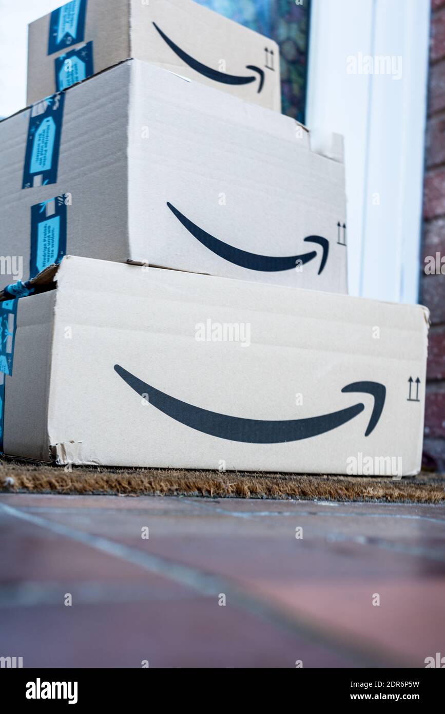 Amazon prime delivery parcel boxes stacked and left in front of main door of home Stock Photo