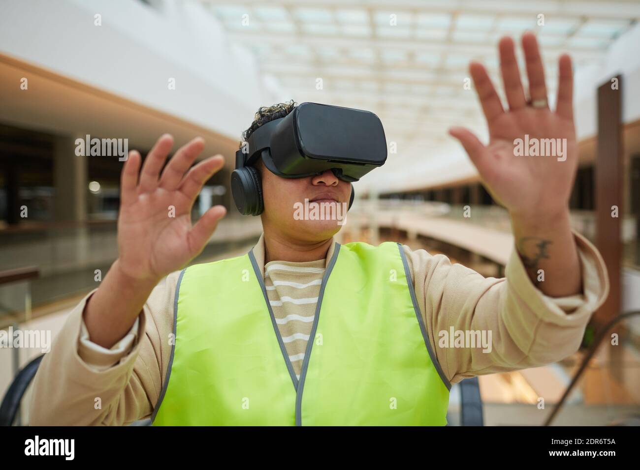 Portrait of female engineer wearing VR headset while visualizing architectural design project Stock Photo