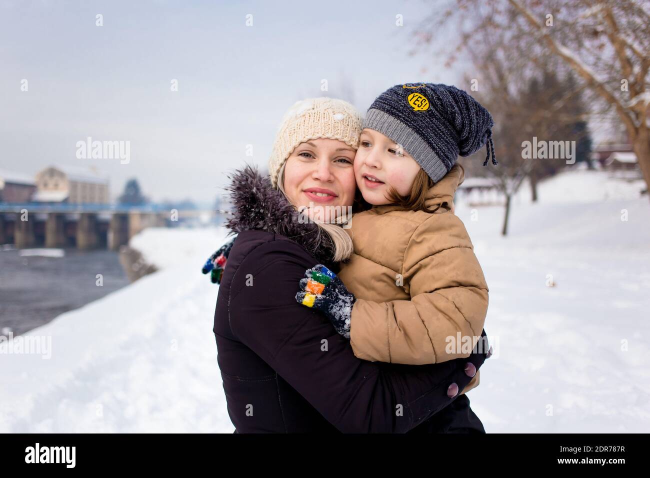 Mom and son in winter clothing hugging Stock Photo