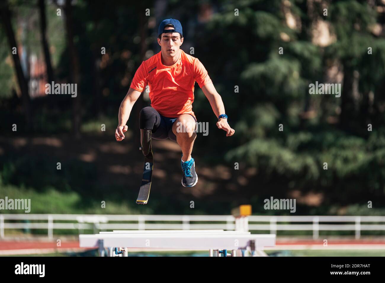 Young Athlete With Prosthetic Leg Jumping Above Railings At Running
