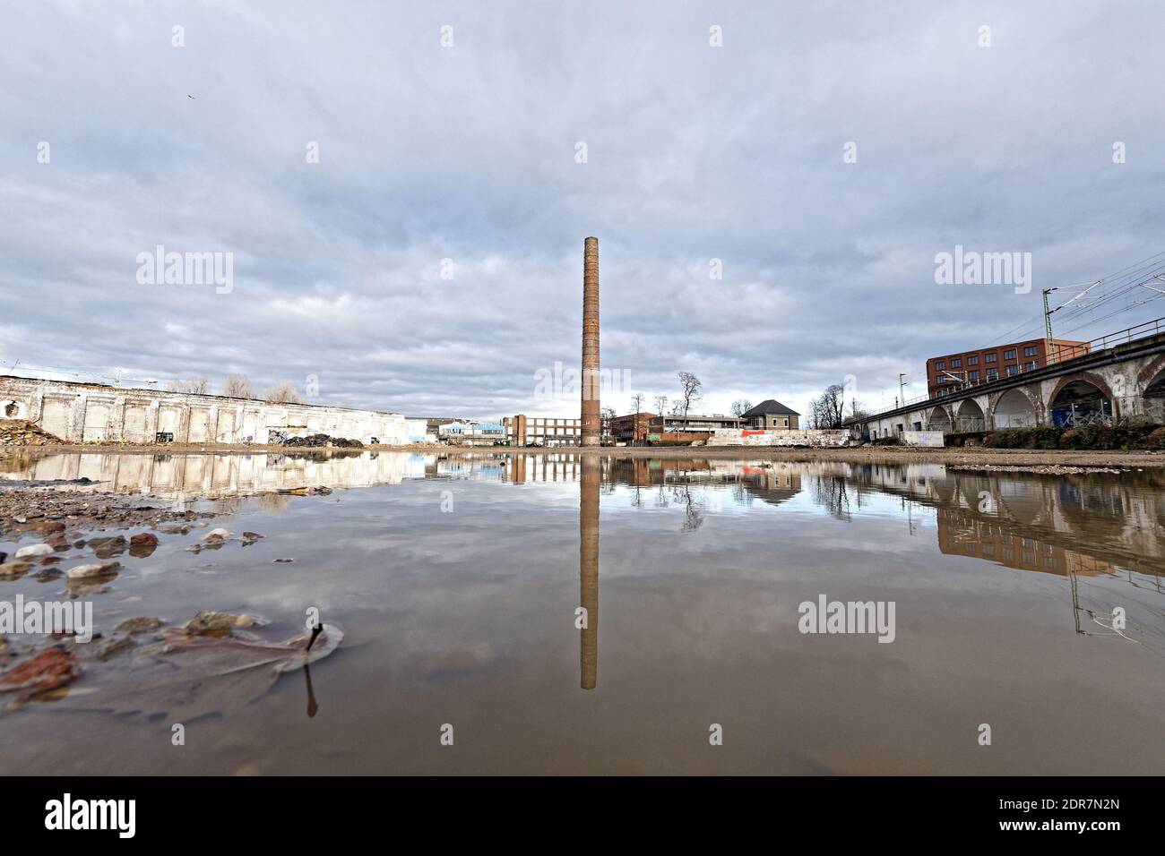 industrial wasteland with lonely chimney reflected in a puddle in cologne Stock Photo