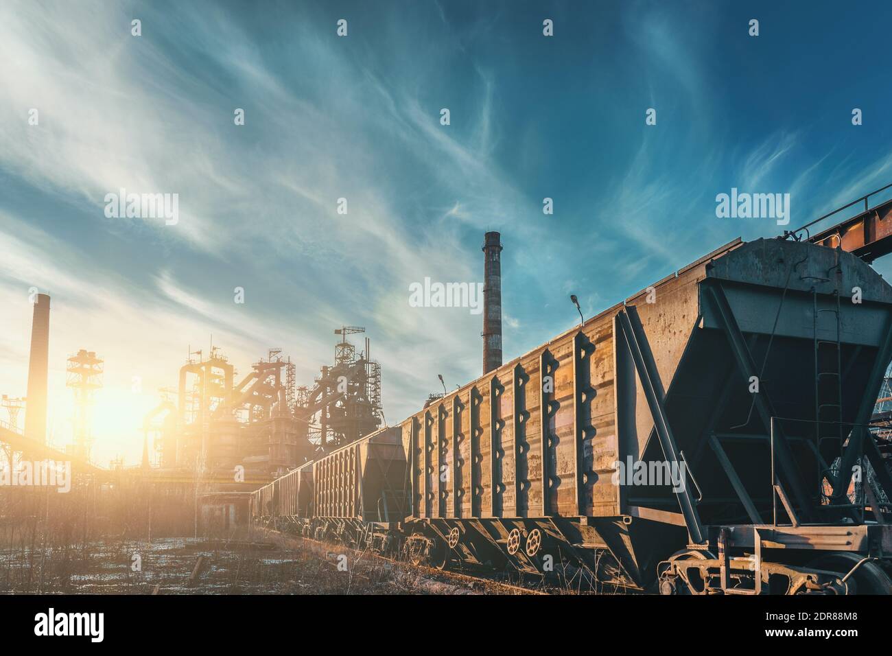 Blast furnace of metallurgical plant with industrial railroad and freight wagons. Stock Photo