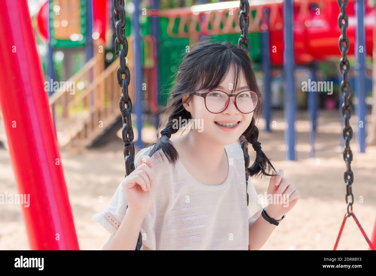 Portrait Of Smiling Young Woman Sitting On Swing At Playground Stock ...