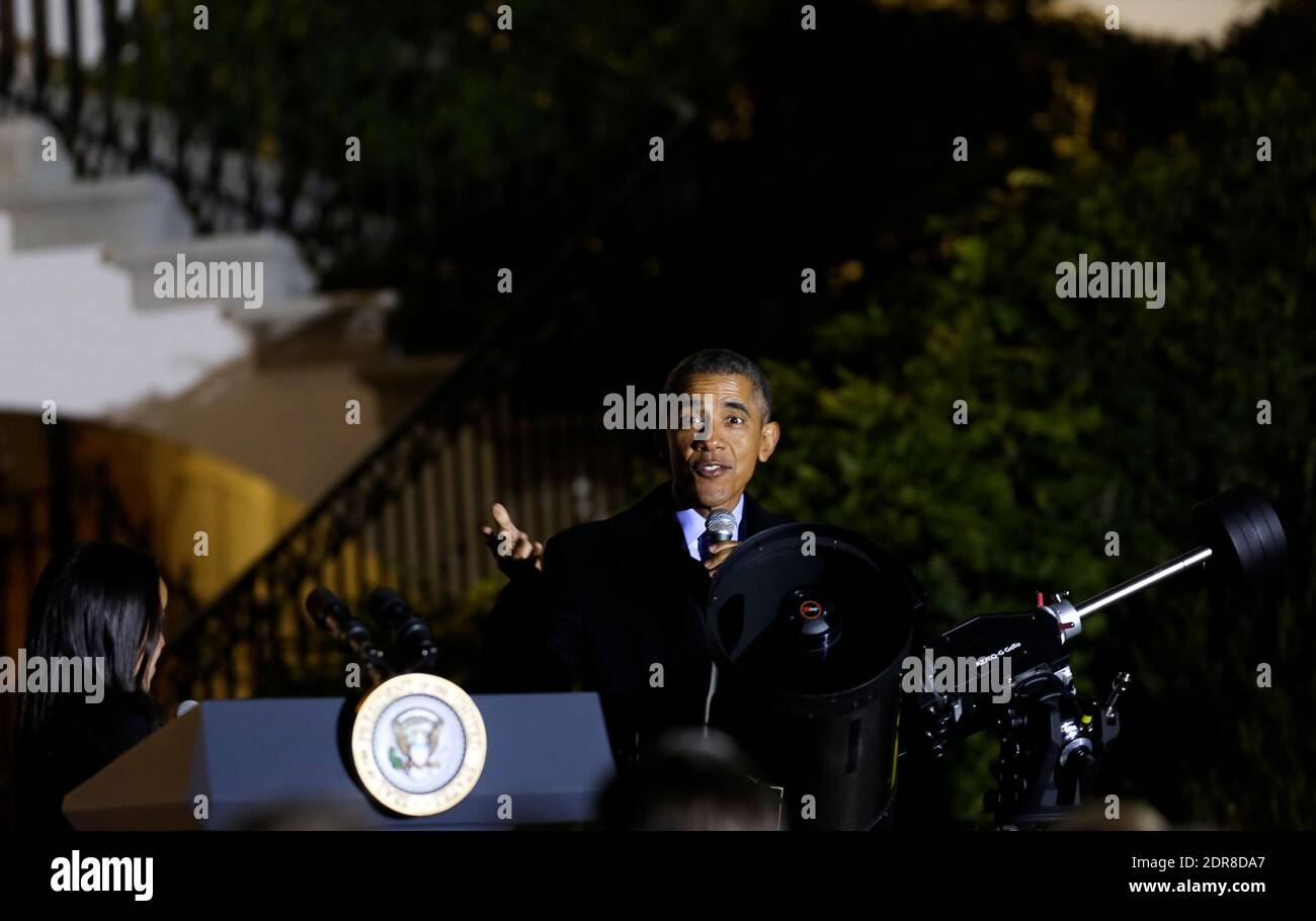 US President Barack Obama gets ready to look through a telescope with the help of Agatha Sofia Alvarez-Bareiro after delivering remarks at the second White House Astronomy Night attended by students, teachers, scientists, astronauts and others in the South Lawn of the White House in Washington, DC, USA, on october 19, 2015. Photo by Aude Guerrucci/Pool/ABACAPRESS.COM Stock Photo